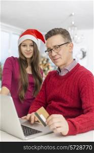 Portrait of father and daughter shopping online during Christmas