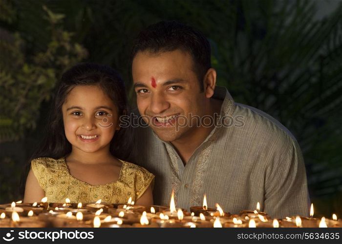 Portrait of father and daughter with diyas