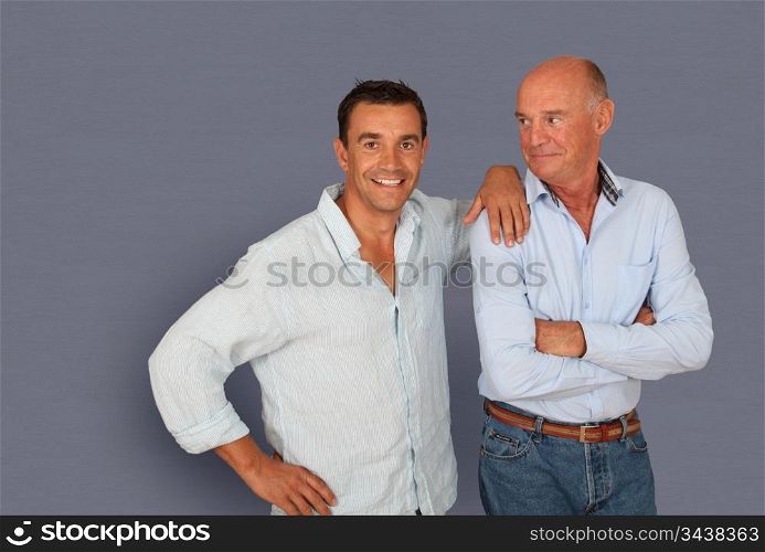 Portrait of father and son on grey background