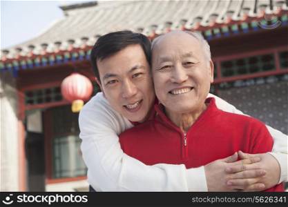 Portrait of father and son outside traditional Chinese building