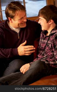 Portrait Of Father And Son Relaxing On Sofa Together