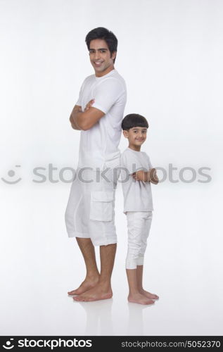 Portrait of father and son standing back to back