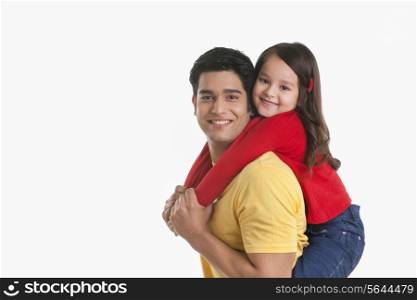 Portrait of father giving daughter piggy back ride