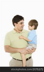 Portrait of father holding son against white background.