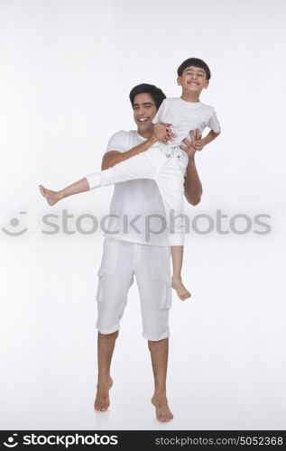 Portrait of father lifting son in the air