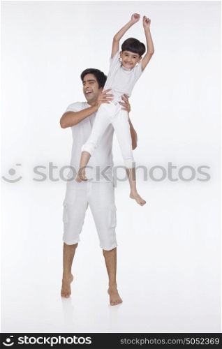 Portrait of father lifting son in the air