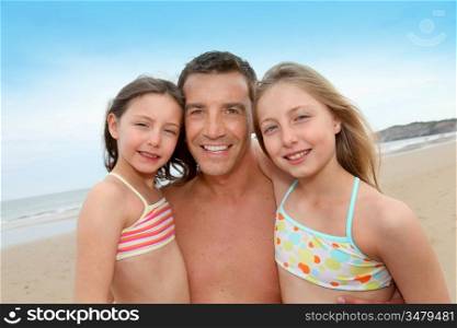 Portrait of father with daughters at the beach
