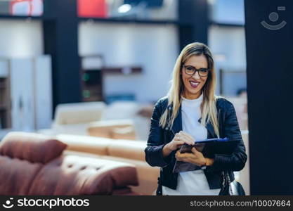 Portrait of female architect with plans in home design showroom