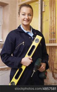 Portrait Of Female Builder With Spirit Level And Electric Drill