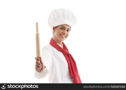 Portrait of female chef holding rolling pin isolated over white background