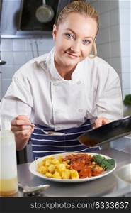 Portrait Of Female Chef Working In Restaurant Kitchen