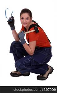 portrait of female craftsman holding hammer and protective goggles