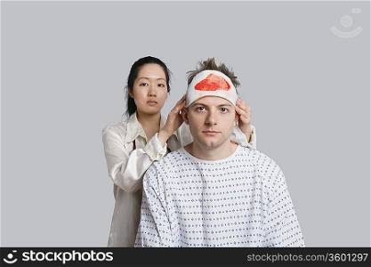 Portrait of female doctor examining injured male patient