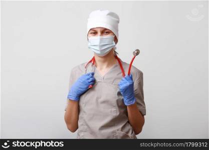 Portrait of female doctor in medical uniform and wearing protective mask. Stethoscope on the neck. Isolated on white background. Healthcare And Medicine. Disease prevention concept. Portrait of female doctor in medical uniform and wearing protective mask. Stethoscope on the neck. Isolated on white background. Healthcare And Medicine. Disease prevention concept.