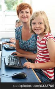 Portrait Of Female Elementary Pupil In Computer Class With Teacher