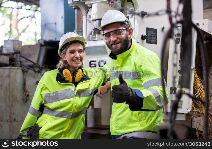 Portrait of female Engineer standing with confident against machine environment in factory, Engineers operating a machine in factory