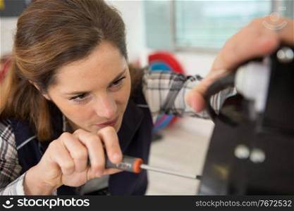 portrait of female engineer using a screwdriver