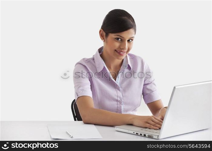 Portrait of female executive working on laptop