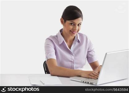 Portrait of female executive working on laptop
