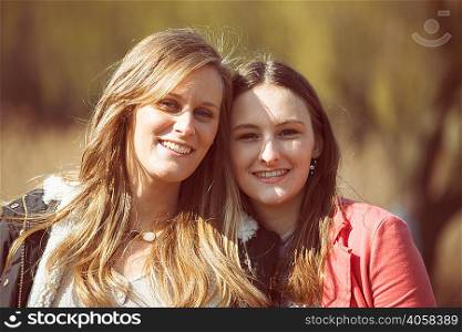 Portrait of female friends looking at camera smiling