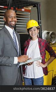 Portrait of female industrial worker standing with male inspector