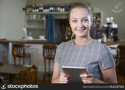 Portrait Of Female Manager In Restaurant With Digital Tablet