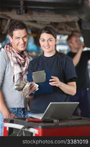 Portrait of female mechanic worker standing with customer