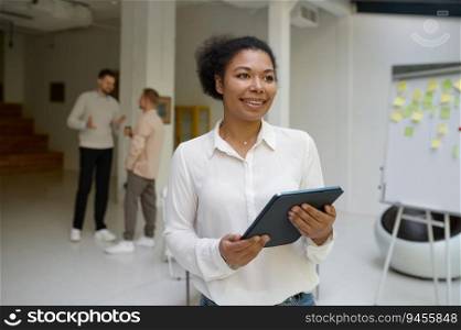 Portrait of female office worker holding digital tablet in hand looking forward while business colleagues talking on blurred background. Successful meeting and negotiation concept. Portrait of female office worker holding digital tablet in hand