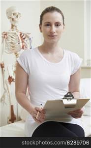 Portrait Of Female Osteopath In Consulting Room