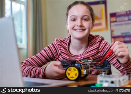 Portrait Of Female Pupil Building Robot Car In School Science Lesson