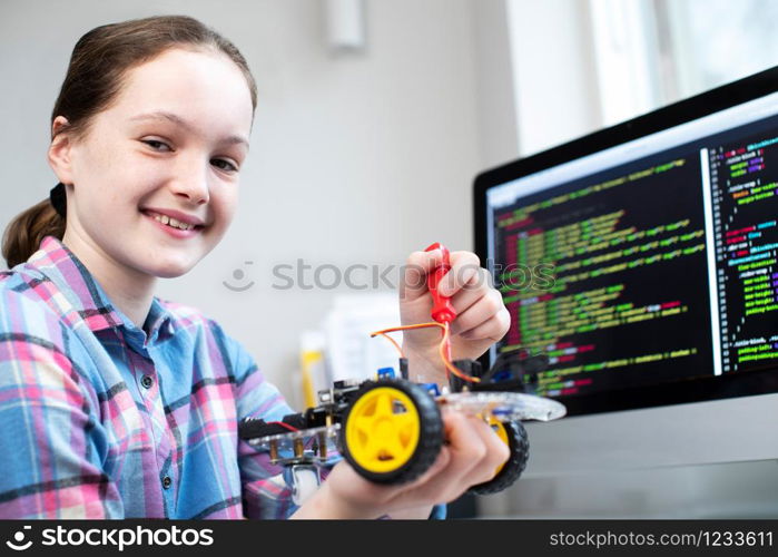 Portrait Of Female Pupil Building Robotic Car In Science Lesson