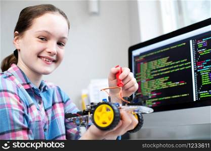 Portrait Of Female Pupil Building Robotic Car In Science Lesson