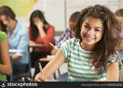 Portrait Of Female Pupil Studying At Desk In Classroom
