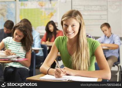 Portrait Of Female Pupil Studying At Desk In Classroom