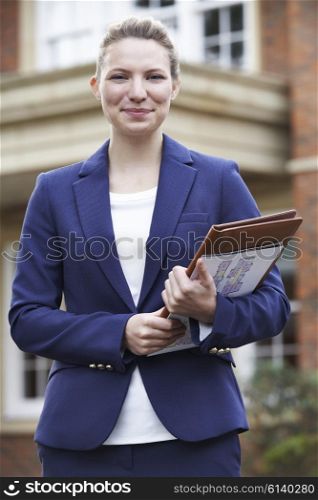 Portrait Of Female Realtor Standing Outside Residential Property