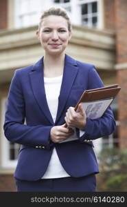 Portrait Of Female Realtor Standing Outside Residential Property