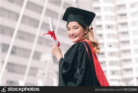 Portrait of female student wearing uniform and cap of graduation. She holding certificate and smiling with success, happiness, proud. Education Concept.