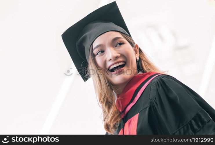 Portrait of female student wearing uniform and cap of graduation. She smiling with success, happiness and proud. Education Concept.