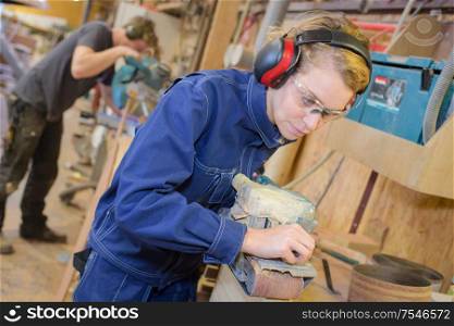 portrait of female woodworker wood sanding