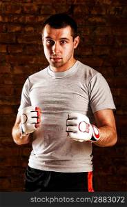 portrait of fighter in boxing pose against brick wall