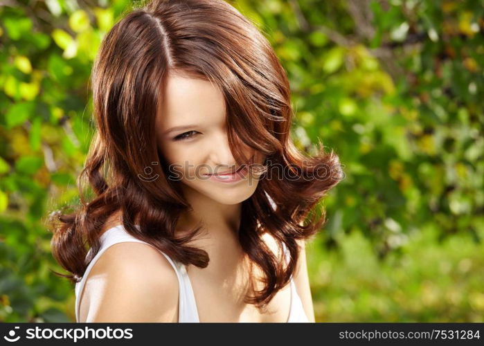 Portrait of fine curly woman in a summer garden