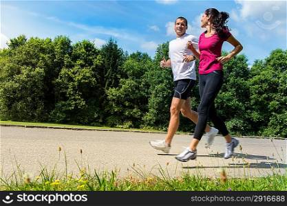 Portrait of fit Caucasian couple running outdoors