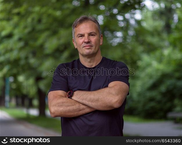 portrait of fit muscular male runner training for marathon running on beautiful road in nature.. portrait of male runner