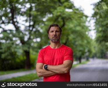 portrait of fit muscular male runner training for marathon running on beautiful road in nature.. portrait of male runner