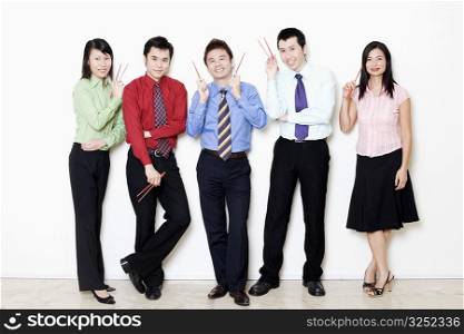 Portrait of five business executives holding chopsticks