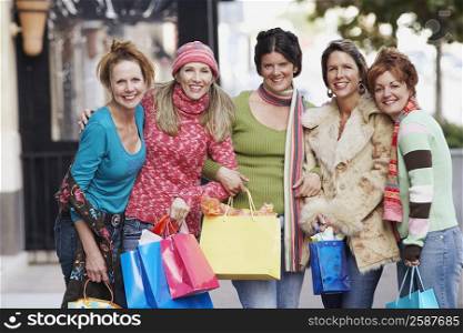 Portrait of five mature women holding shopping bags