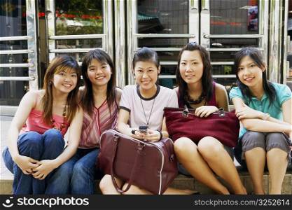 Portrait of five young women sitting together and smiling