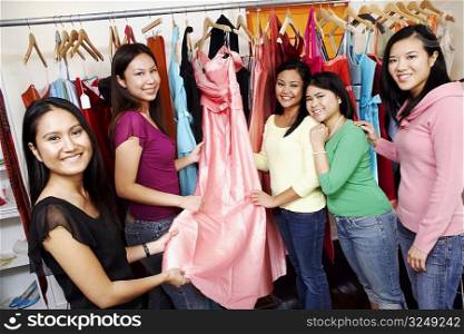 Portrait of five young women standing in a clothing store