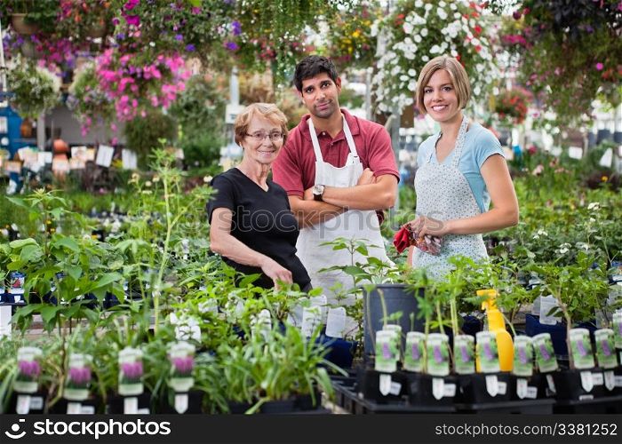 Portrait of florists standing with female customer