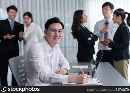 Portrait of focus young successful confident male manager, executive wearing business wear in harmony office arm crossed with blurred meeting background of colleagues, office worker.. Portrait of focus successful confident male manager in harmony office.